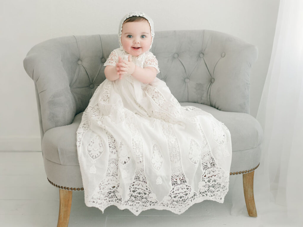 Baby girl wearing a white lace baptism gown