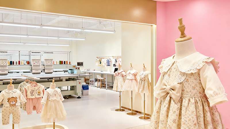 Kidswear showroom displaying embroidered dresses and rompers